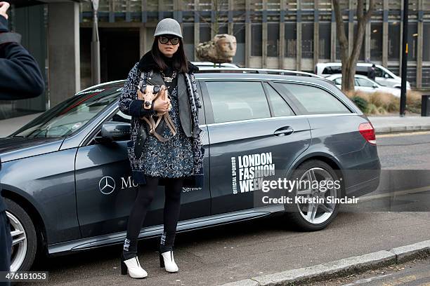 Fashion Editor at Elle China Leaf Greener wears a Stella McCartney hat, Chanel glasses, necklace, top, jacket and shirt, Yadu bag, Charline de Luca...