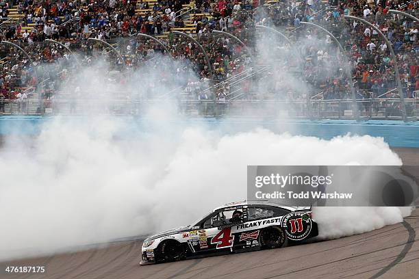 Kevin Harvick, driver of the Jimmy John's Chevrolet, celebrates with a burnout after winning the NASCAR Sprint Cup Series The Profit On CNBC 500 at...