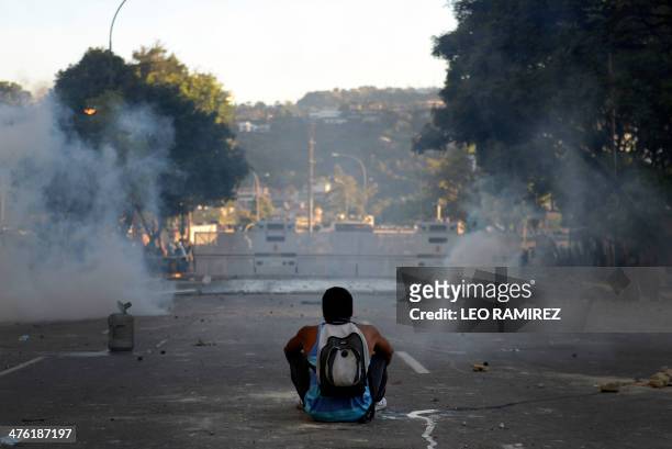 Demonstrator sits on the street during a protest against the government of Venezuelan President Nicolas Maduro, in Caracas on March 2, 2014....