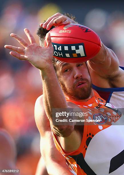 Shane Mumford of the Giants contests the ball during the round 10 AFL match between the Greater Western Sydney Giants and the Brisbane Lions at...