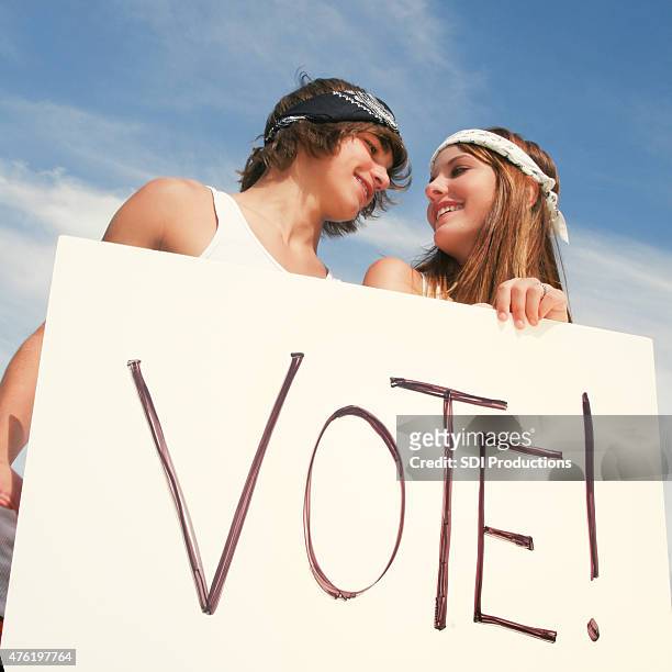 young adults holding vote sign outdoors during campaign - young voters stockfoto's en -beelden