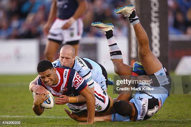 Daniel Tupou of the Roosters is tackled by Jeff Robson and Jayson Bukuya of the Sharks during the round 13 NRL match between the Sharks and the...