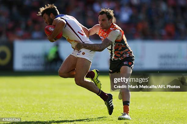 Rohan Bewick of the Lions is tackled by Nathan Wilson of the Giants during the round 10 AFL match between the Greater Western Sydney Giants and the...