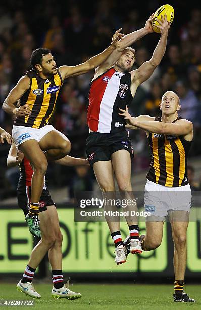 Luke Delaney of the Saints marks the ball against Cyril Rioli and David Hale of the Hawks during the round 10 AFL match between the St Kilda Saints...