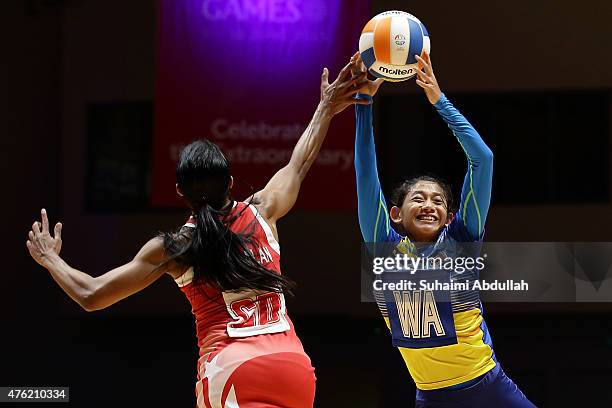 Premila Hirubalan of Singapore and Nurfariha Abdul Razak of Malaysia challenge for the ball during the women's netball gold medal match between...