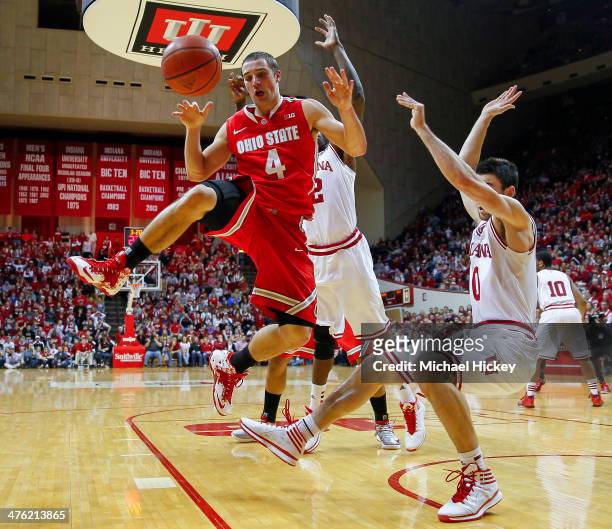 Aaron Craft of the Ohio State Buckeyes loses the ball while shooting as Will Sheehey of the Indiana Hoosiers falls to the ground at Assembly Hall on...