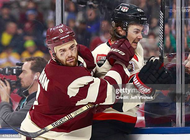 Zack Kassian of the Vancouver Canucks checks Erik Karlsson of the Ottawa Senators during the 2014 Tim Hortons NHL Heritage Classic at BC Place...