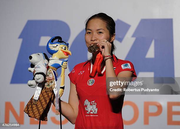 Ratchanok Intanon of Thailand poses on the podium after winning Women's Final against Yui Hashimoto of Japan during the 2015 BCA Indonesia Open at...