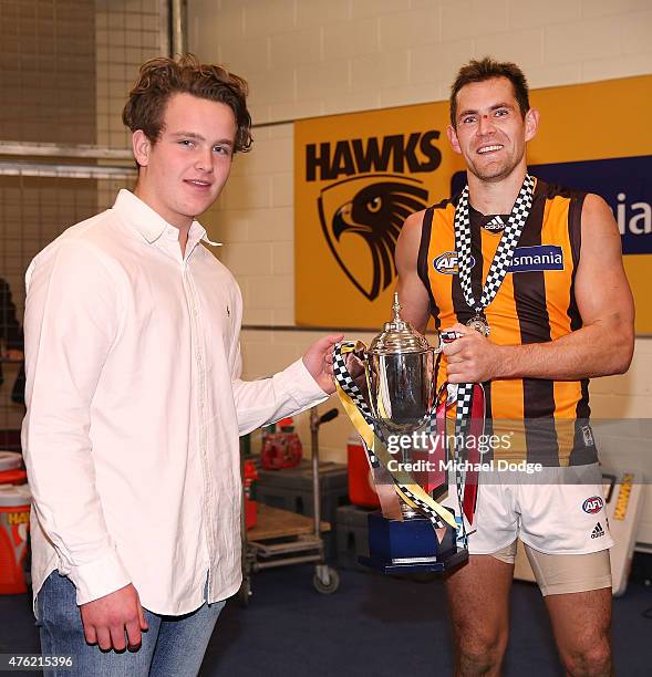 The Blue Ribbon Cup is presented to Luke Hodge of the Hawks by Jimmy Miller, the son of Constable Rodney Miller, during the round 10 AFL match...