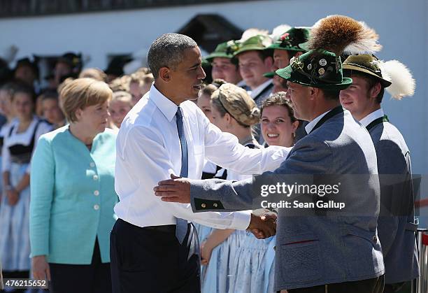 President Barack Obama and German Chancellor Angela Merkel greet locals dressed in traditional Bavarian folk dress before the two leaders were...