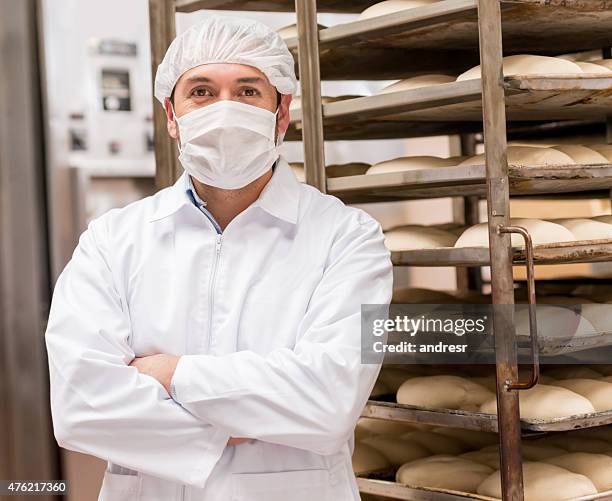 man working at an industrial bakery - garment stock pictures, royalty-free photos & images