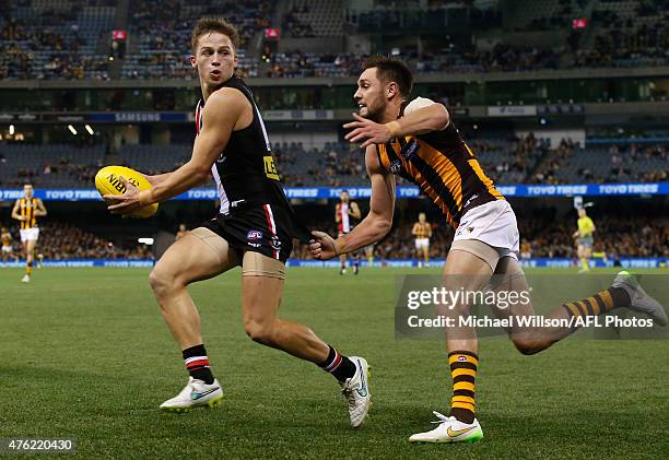 Jack Billings of the Saints is chased by Jack Gunston of the Hawks during the 2015 AFL round ten match between the St Kilda Saints and the Hawthorn...