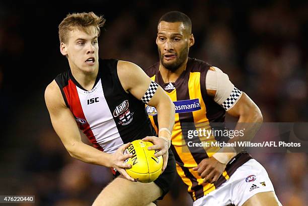 Jack Lonie of the Saints is chased by Josh Gibson of the Hawks during the 2015 AFL round ten match between the St Kilda Saints and the Hawthorn Hawks...