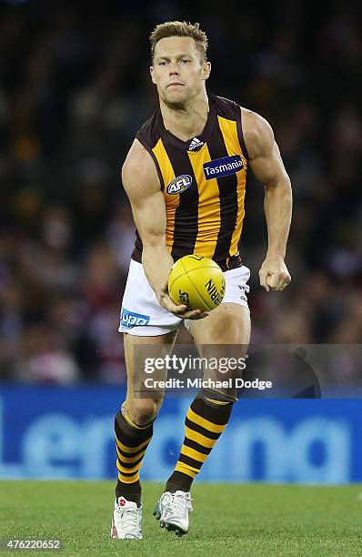 Sam Mitchell of the Hawks handballs during the round 10 AFL match between the St Kilda Saints and the Hawthorn Hawks at Etihad Stadium on June 7,...