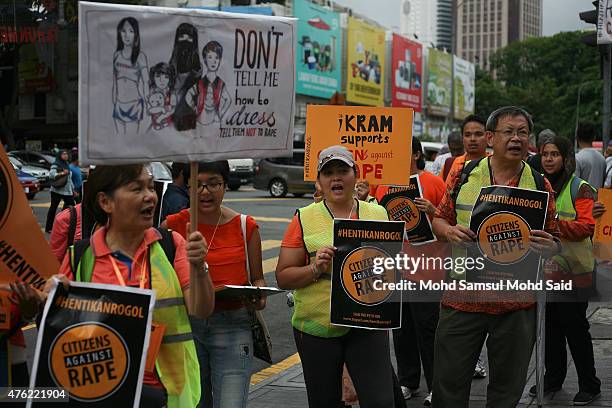 Members of All Women's Action Society , a Malaysia non-government organisation, hold placards during a peaceful public protest titled 'Citizens...