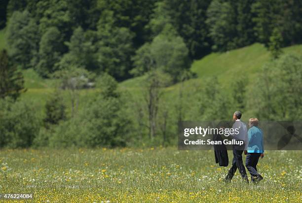President Barack Obama and German Chancellor Angela Merkel stroll outside at the summit of G7 nations at Schloss Elmau on June 7, 2015 near...