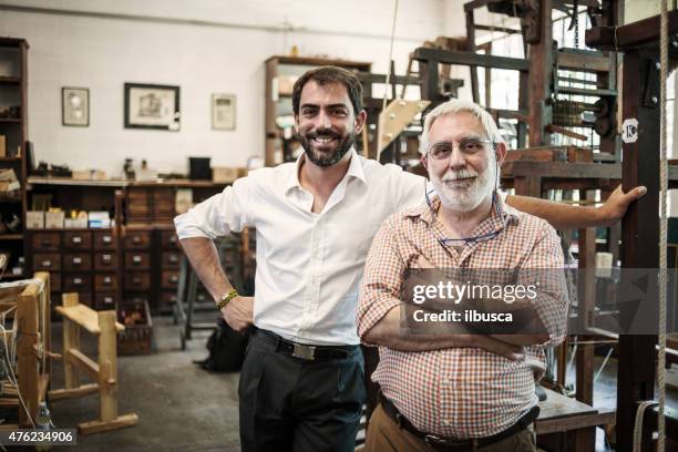 father and son in their artisanal handicraft traditional textile factory - two generation family stock pictures, royalty-free photos & images