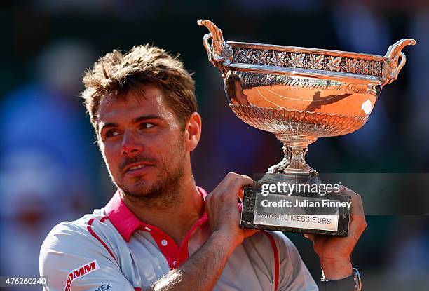 Stanislas Wawrinka of Switzerland holds the Coupe de Mousquetaires after victory in the Men's Singles Final against Novak Djokovic of Serbia on day...