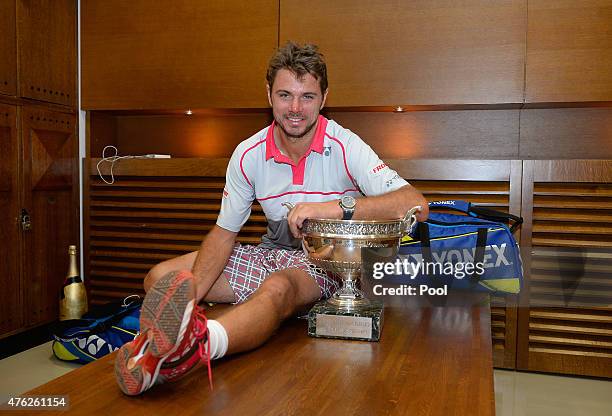 Stanislas Wawrinka of Switzerland poses with the Coupe de Mousquetaires after victory in his changing room after the Men's Singles Final against...