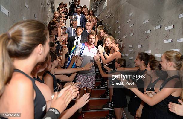 Stanislas Wawrinka of Switzerland makes his way through a ball kid guard of honour to his changing room after victory the Men's Singles Final against...