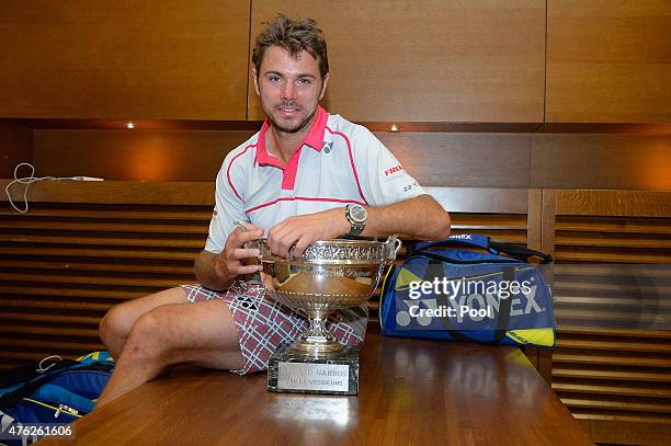 Stanislas Wawrinka of Switzerland poses with the Coupe de Mousquetaires after victory in his changing room after the Men's Singles Final against...