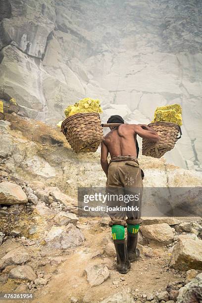 asian worker carrying baskets of sulfur in ijen volcano - slave holder stock pictures, royalty-free photos & images