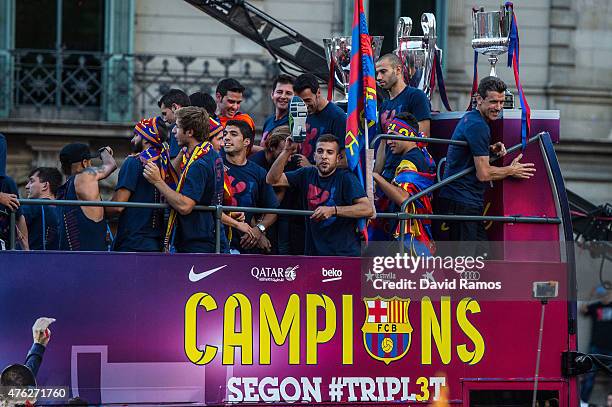 Barcelona players celebrate on an open top bus during their victory parade after winning the UEFA Champions League Final on June 7, 2015 in...