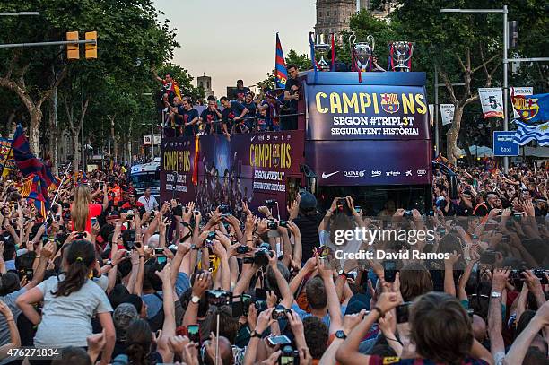 Barcelona players celebrate on an open top bus during their victory parade after winning the UEFA Champions League Final on June 7, 2015 in...