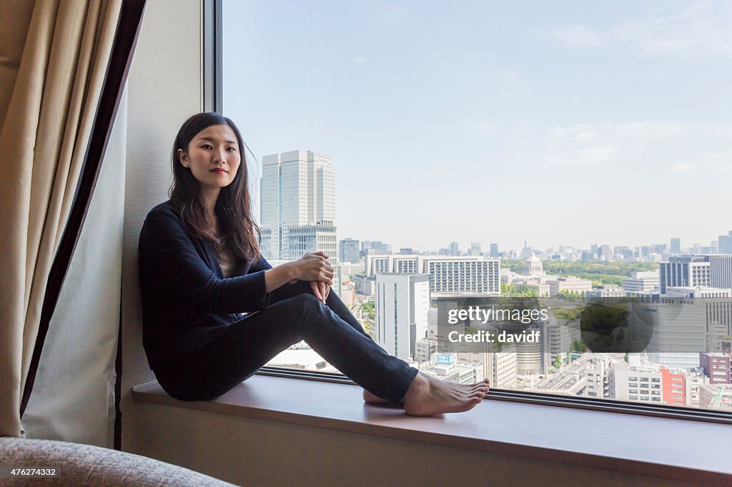 Young modern Japanese woman sitting looking at the view