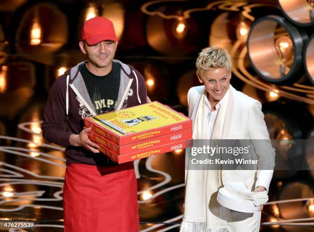 Host Ellen DeGeneres with pizza delivery man onstage during the Oscars at the Dolby Theatre on March 2, 2014 in Hollywood, California.