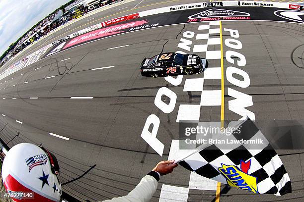 Martin Truex Jr., driver of the Furniture Row/Visser Precision Chevrolet, takes the checkered flag to win the NASCAR Sprint Cup Series Axalta 'We...