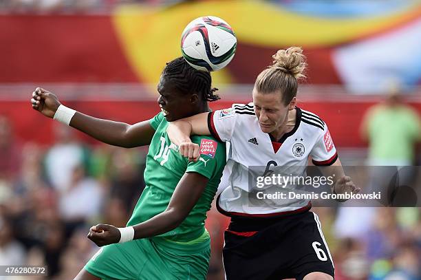 Josee Nahi of Cote D'Ivoire and Simone Laudehr of Germany go up for a header during the FIFA Women's World Cup Canada 2015 Group B match between...