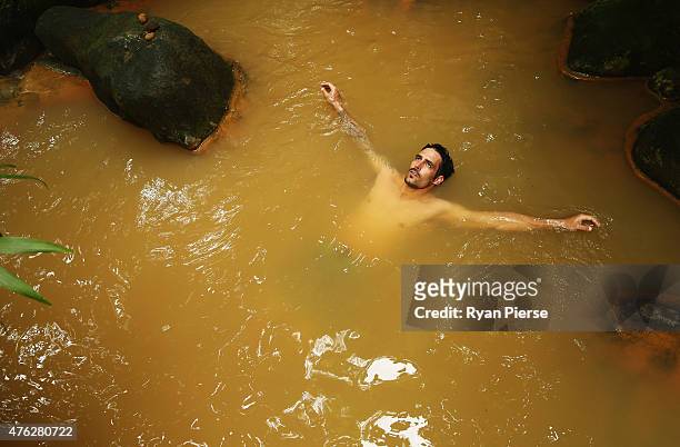 Mitchell Johnson of Australia swims in the hot springs during the Australian Cricket Team's visit to Trafalgar Falls on June 7, 2015 in Roseau,...