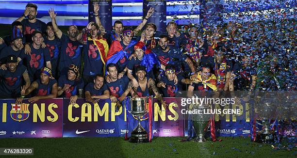 Barcelona players pose with the three trophies as they take part in the celebrations held for their victory over Juventus, one day after the UEFA...