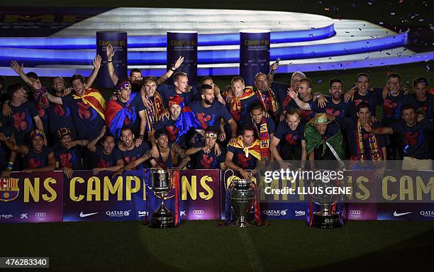 Barcelona players pose with the three trophies as they take part in the celebrations held for their victory over Juventus, one day after the UEFA...