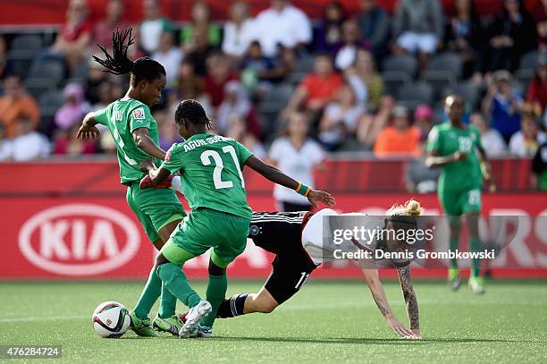 Anja Mittag of Germany is challenged by Sophie Aguie and Fatou Coulibaly of Cote D'Ivoire during the FIFA Women's World Cup Canada 2015 Group B match...