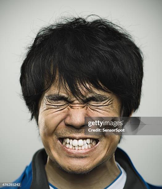 porträt eines jungen japanischen mann unter stress - pain face stock-fotos und bilder