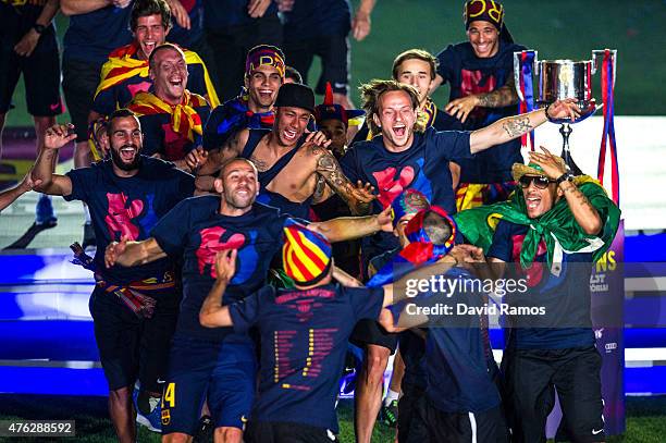 Barcelona players celebrate with La Liga, Copa del Rey and Champions League trophies during their victory parade after winning the UEFA Champions...