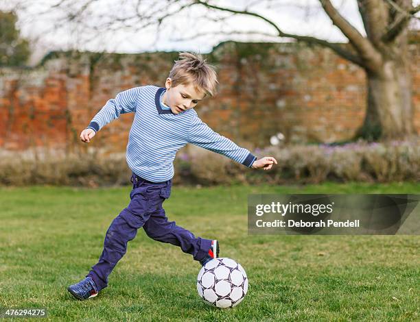 young boy playing football in the garden - long sleeve t shirt stock pictures, royalty-free photos & images