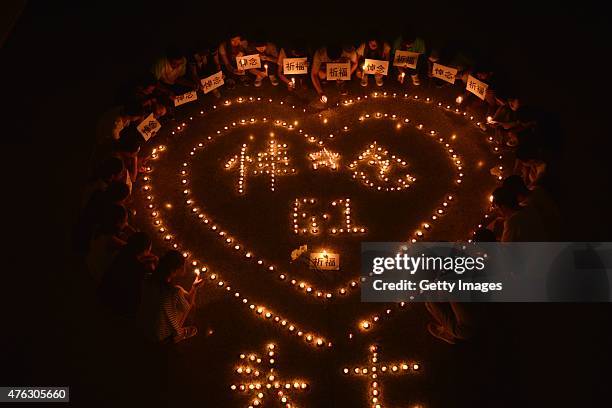 Students from Liaocheng University light candles to mourn victims onboard Chinese cruise Eastern Star at Liaocheng University on June 7, 2015 in...