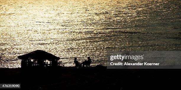 Burundis sit during sunset at Lake Tanganyika on June 7, 2015 in Bujumbura, Burundi. Protests have been laid down over the weekend and the situation...