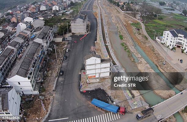 This photo taken on March 10, 2015 shows two "nail houses" standing in the middle of a road under construction in Yongjia, in eastern China's...