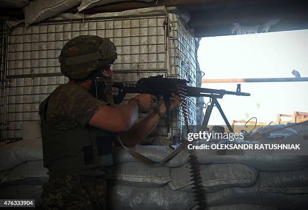 An Ukrainian serviceman shoots on the front line in Opytne village, close to Donetsk airport on June 7, 2015. The first day of the G7 summit opened...