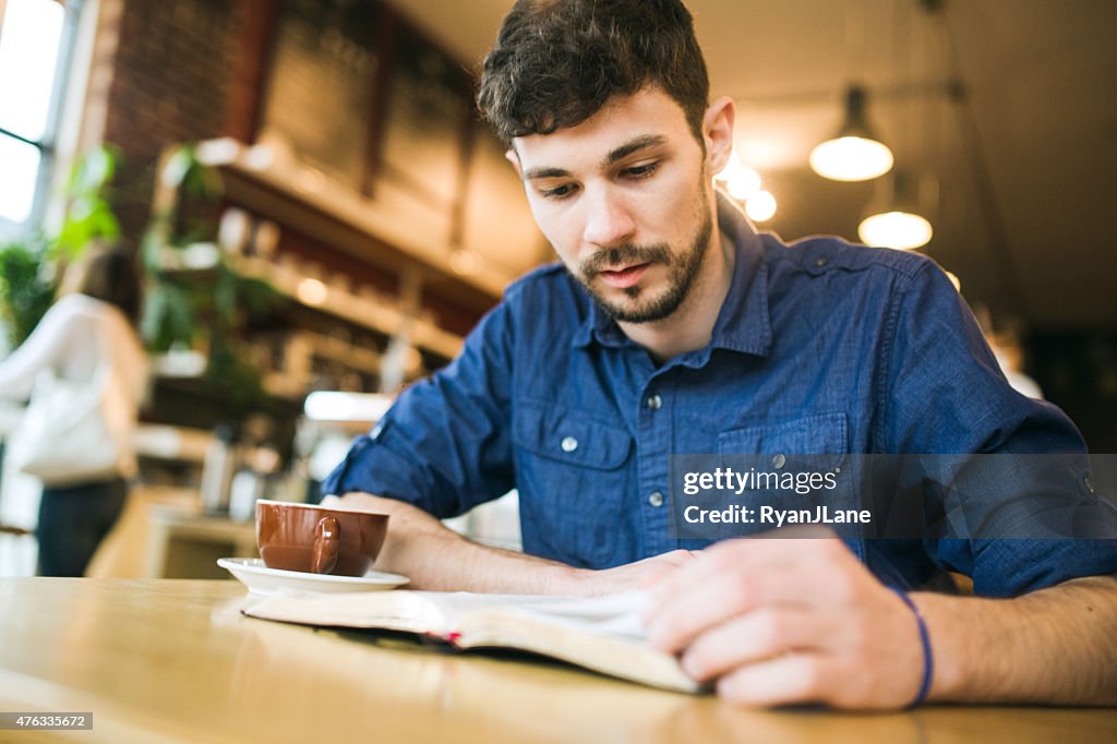 Man Reading Book in Coffee Shop