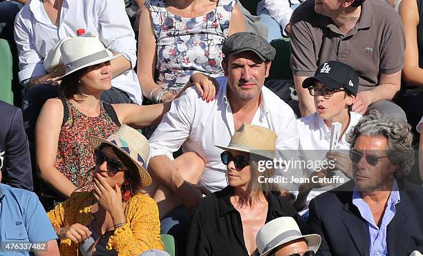 Jean Dujardin sits between his girlfriend Nathalie Pechalat and his son during the men's final on day 15 of the French Open 2015 at Roland Garros...