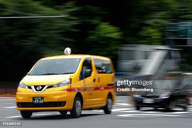 Nissan Motor Co. NV200 Taxi cab for Daiwa Motor Transportation Co., left, drives on a road during a launch event in Tokyo, Japan, on Monday, June 8,...