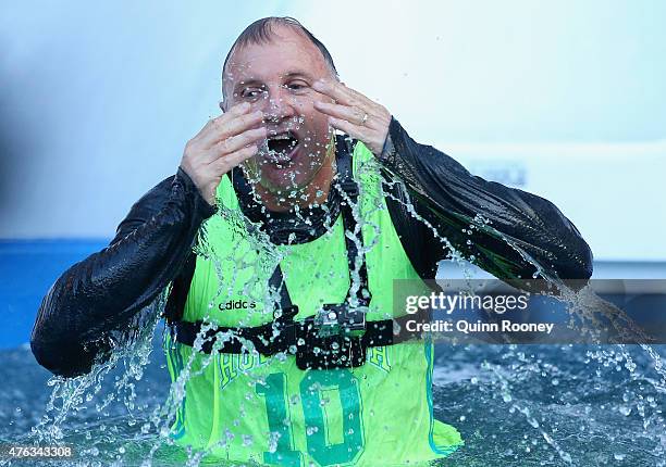 Tim Watson dives into an icebath to raise money for Motor Neurone Disease ahead of the round 10 AFL match between the Melbourne Demons and the...
