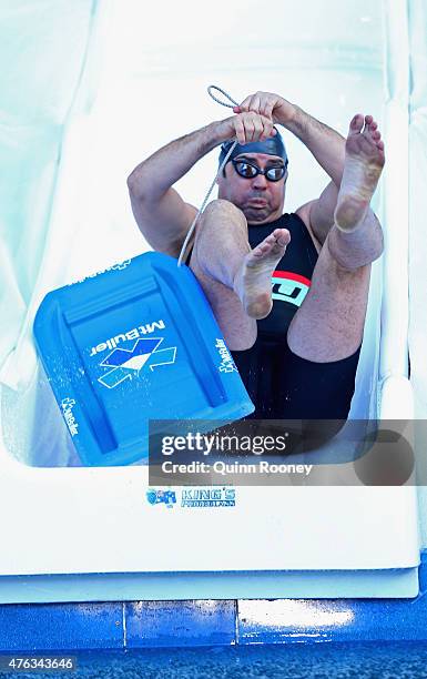 Gary Lyon dives into an icebath to raise money for Motor Neurone Disease ahead of the round 10 AFL match between the Melbourne Demons and the...