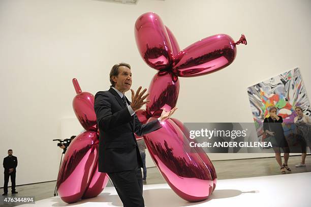 Artist Jeff Koons gestures past one of his piece of art during the presentation of the "Jeff Koons: Retrospective" exhibition at the Guggenheim...