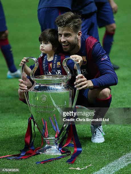 Gerard Pique poses with the trophy alongside his son Milan following the UEFA Champions League Final match between Juventus and FC Barcelona at the...